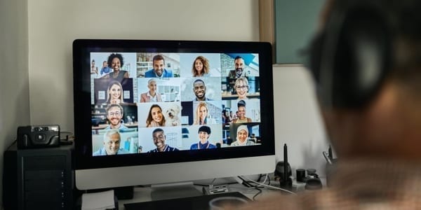 image of mac computer with zoom meeting of 16 people on the screen.