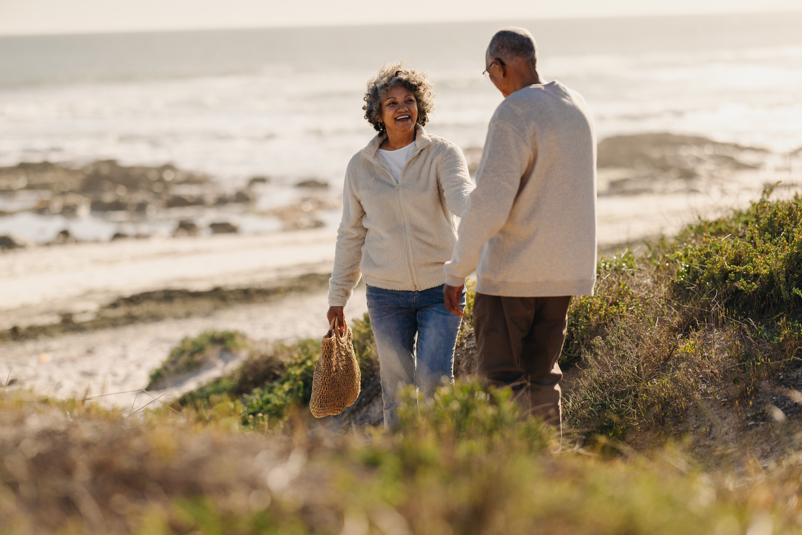 A retired couple walking along a beach.